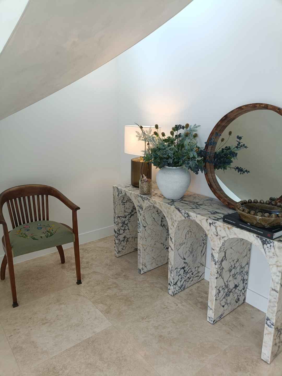 A styled console and mirror vignette, dusted and detailed