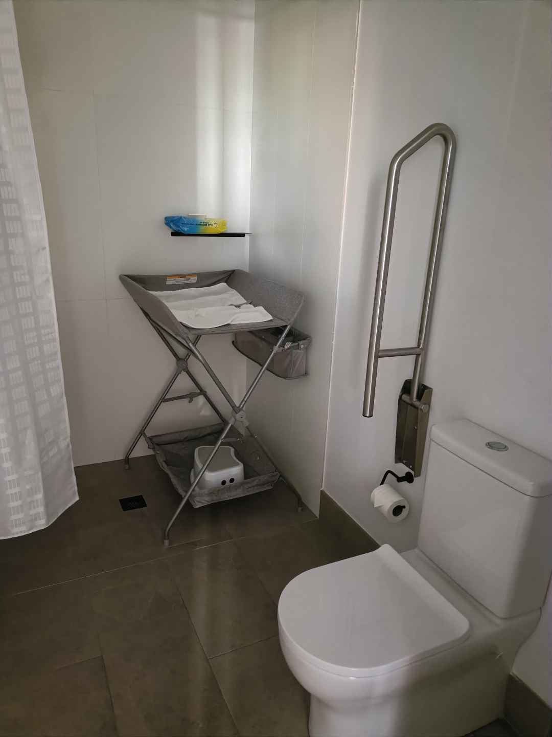 A clean bathroom with a baby change table set up and ready